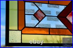 Contemporary stained glass panel with amber and red tones. Decorative window