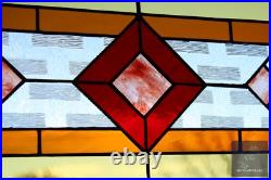 Contemporary stained glass panel with amber and red tones. Decorative window